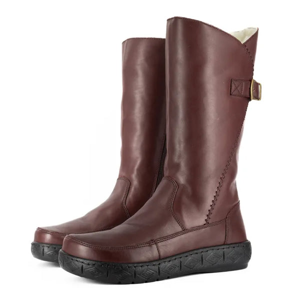 Pair of raisin coloured leather boots with a buckle on a white background