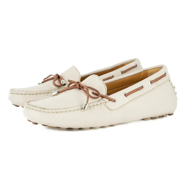 Pair of cream-colored loafers with brown laces on a white background
