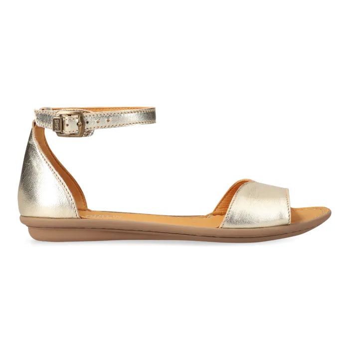 A metallic gold flat sandal with an ankle strap and open toe, shown in profile against a white background.