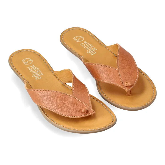 A pair of tan leather thong sandal with a flat sole, shown from a side profile on a white background.