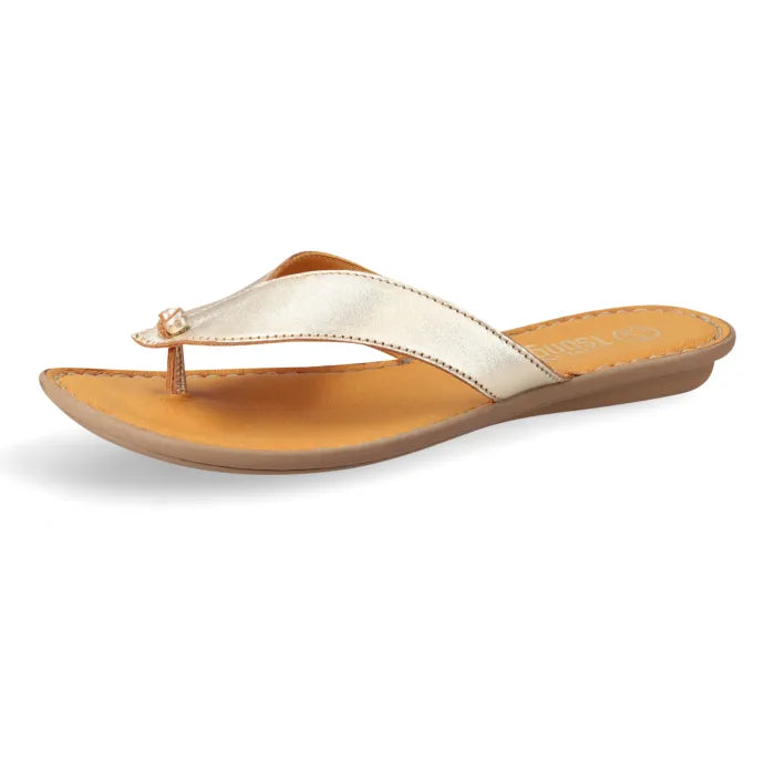 A single women's flat thong sandal shown in side profile on a white background. The sandal features a metallic champagne-gold strap with a small decorative rhinestone accent at the toe post, a tan leather footbed, and a brown outsole.