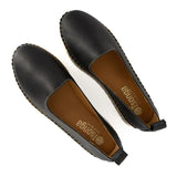 Pair of black loafers with brown soles on a white background