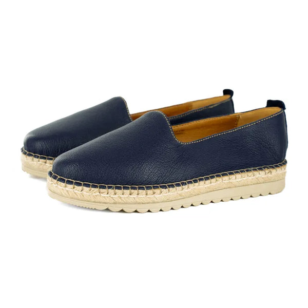 Pair of navy blue espadrilles with beige sole on a white background
