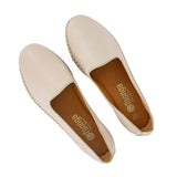 Pair of beige flat shoes with brand name on a white background
