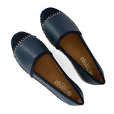 Pair of navy blue loafers with brown soles on a white background