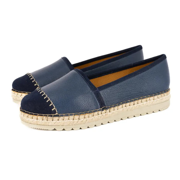 Pair of navy blue espadrilles with off white sole on a white background
