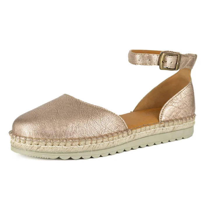 Gold espadrille shoe with a strap and buckle on a white background