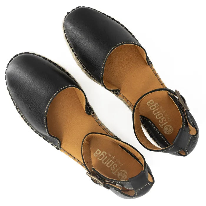 Pair of black sandals with tan soles on a white background