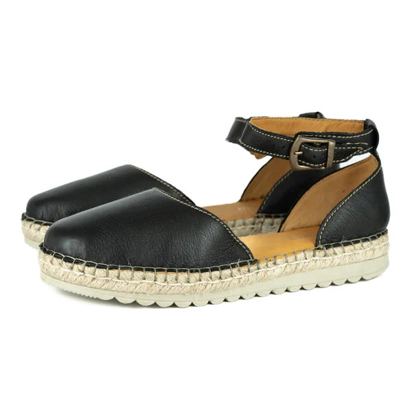 Black espadrille sandals with a tan sole on a white background