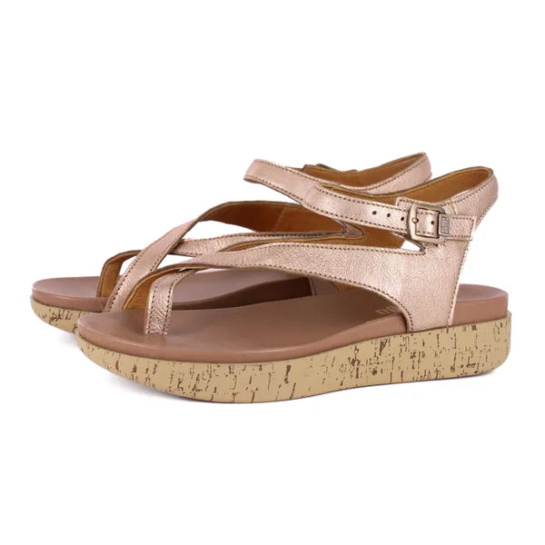 Pair of rose gold sandals with cork print platform sole on a white background