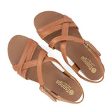 Pair of tan sandals with criss-cross straps on a white background