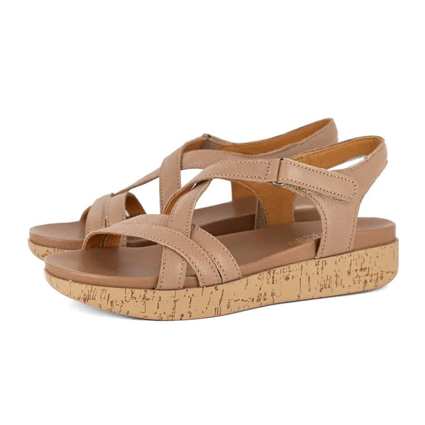 Pair of beige sandals with cork print platform sole on a white background.