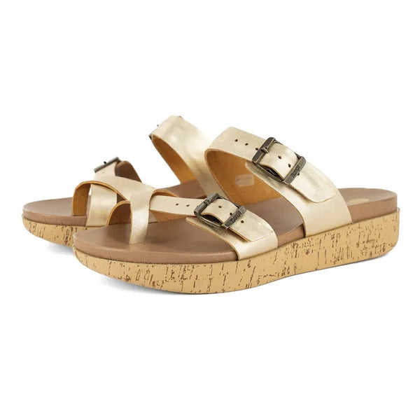 Pair of gold sandals with cork print platforms on a white background