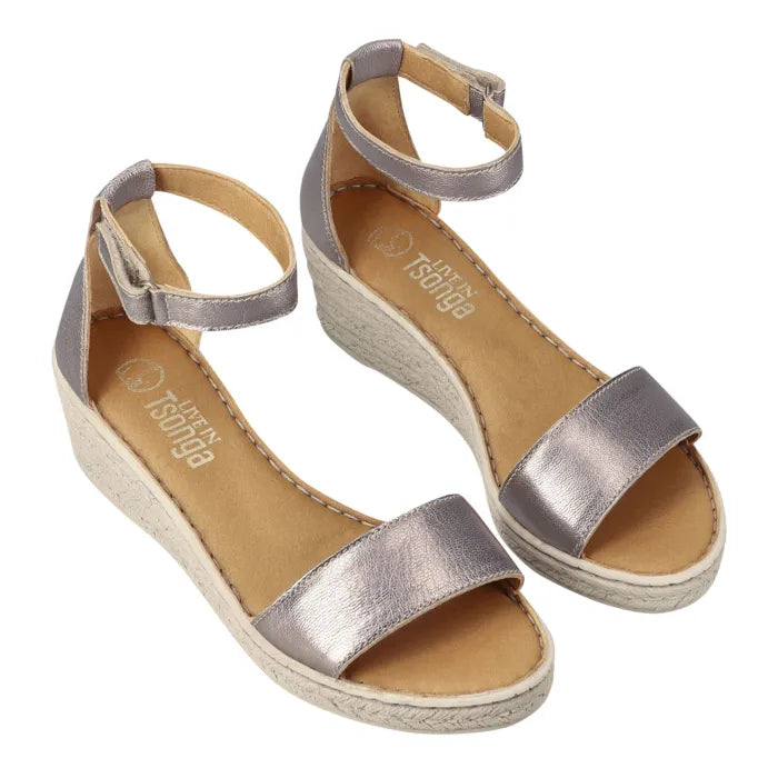 A pair of metallic silver wedge sandals with ankle straps and espadrille-style woven soles, shown on a plain white background.