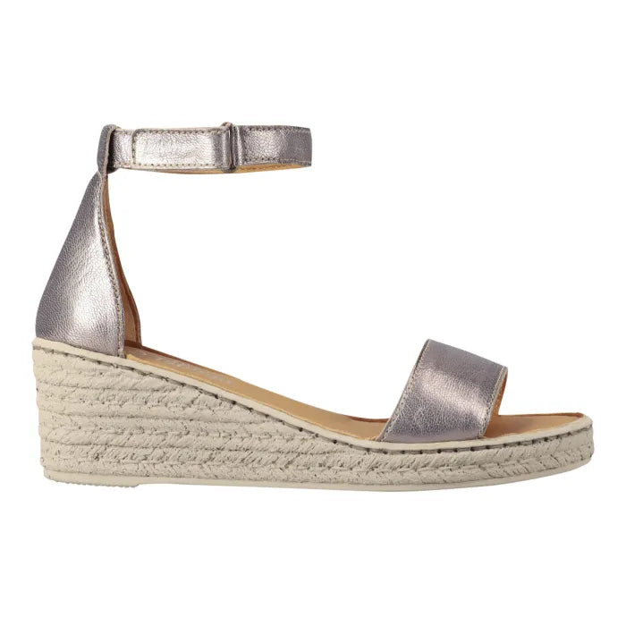 A metallic silver wedge espadrille sandal with an ankle strap and a single toe strap, shown in a side profile on a white background.