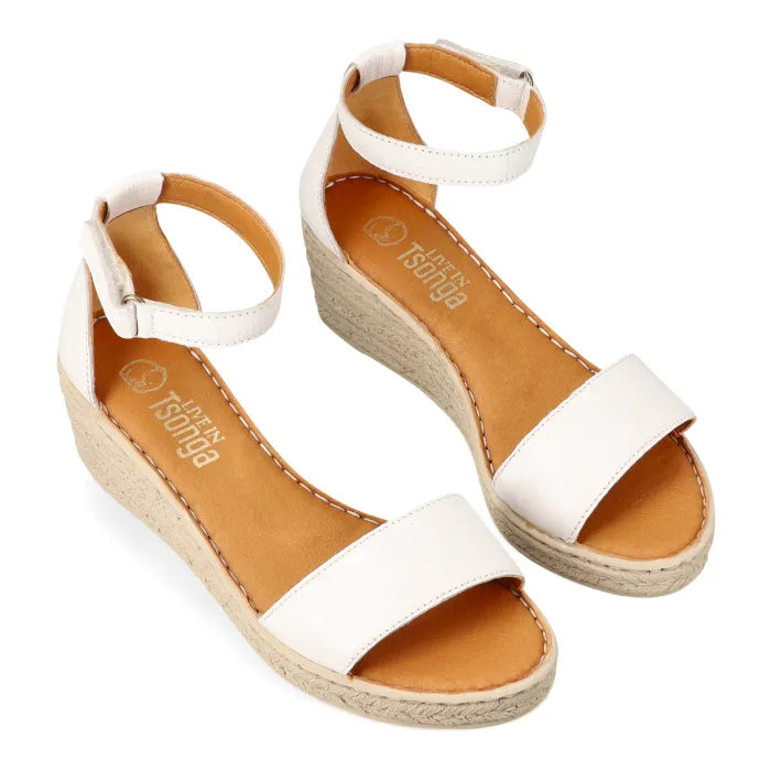 A pair of white espadrille-look wedge sandals with ankle straps, shown on a clean white background. The brand name 'Tsonga' is printed on the tan insoles.