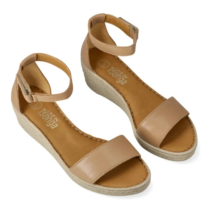 A pair of women's wedge sandals in tan and beige, featuring a single wide strap, adjustable ankle strap with a buckle, and a wedge heel, shown on a white background.