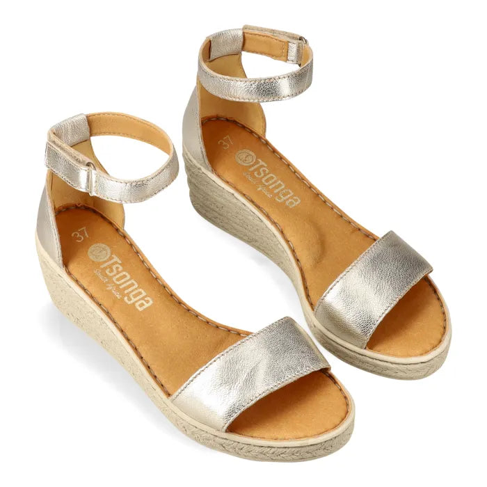 Gold sandals with espadrille print sole on a white background