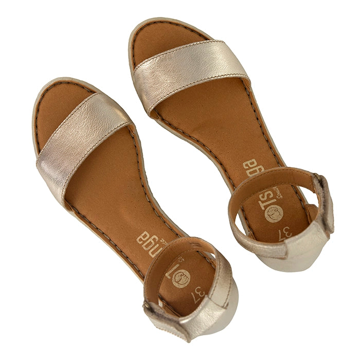 Gold ankle-strap sandals with wedge sole on a white background