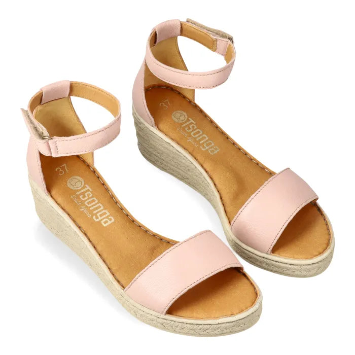 Pair of pink sandals with beige soles on a white background
