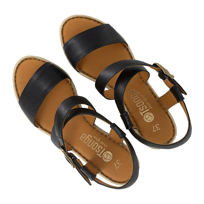 Pair of black sandals with tan soles on a white background