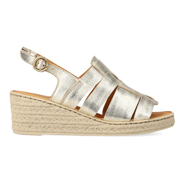 A single metallic gold espadrille looking wedge sandal with an adjustable ankle strap, shown in profile against a white background.