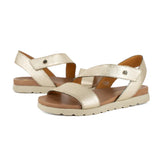 Pair of gold sandals with off white soles on a white background