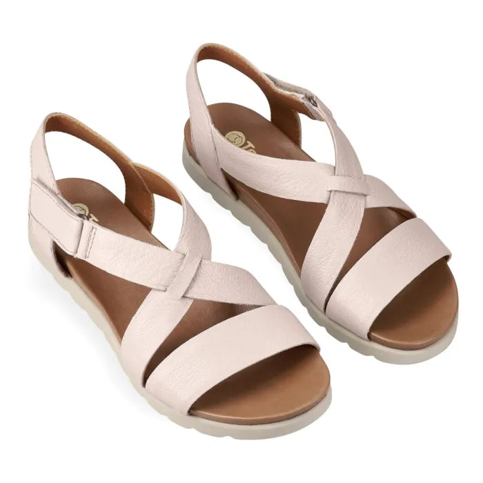 Pair of cream sandals with criss-cross straps on a white background