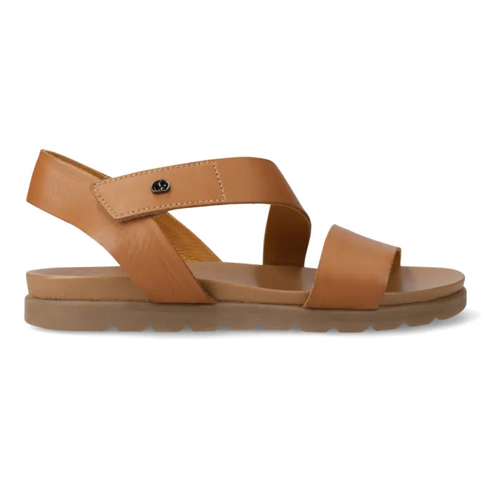 A tan leather flat sandal with a wide front strap, a slingback ankle strap, and a thick brown sole, shown from a side profile on a white background.