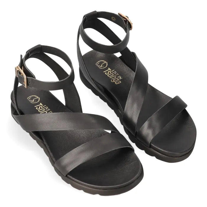A pair of black leather strappy sandals with adjustable ankle straps and gold-tone buckle details, displayed on a clean white background.