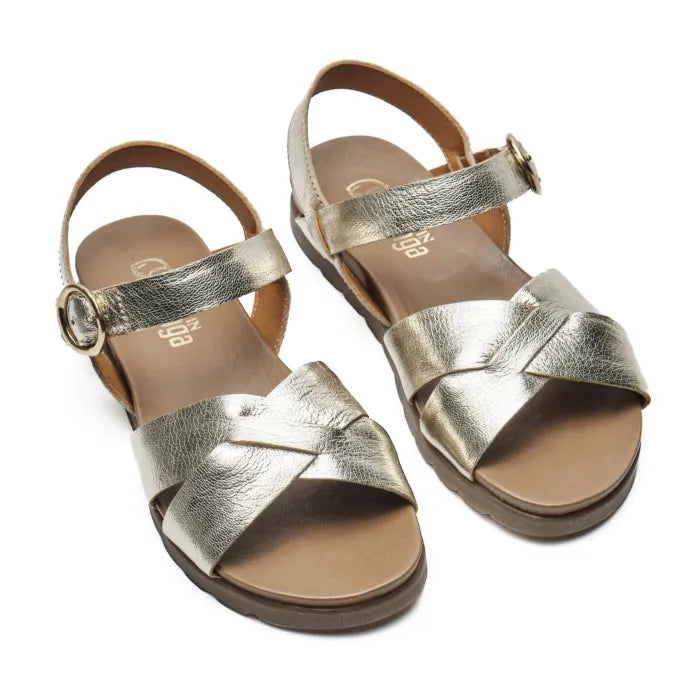 A pair of metallic silver leather slide sandals with crisscross straps and adjustable ankle buckles, shown on a white background.