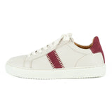 Cream sneaker with maroon accents on a white background