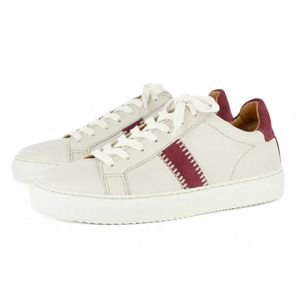 Cream sneakers with maroon accents on a white background