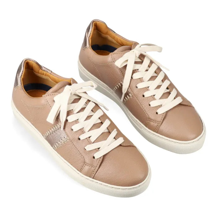 Pair of tan sneakers with white laces on a white background