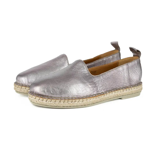 Pair of metallic pink espadrilles on a white background