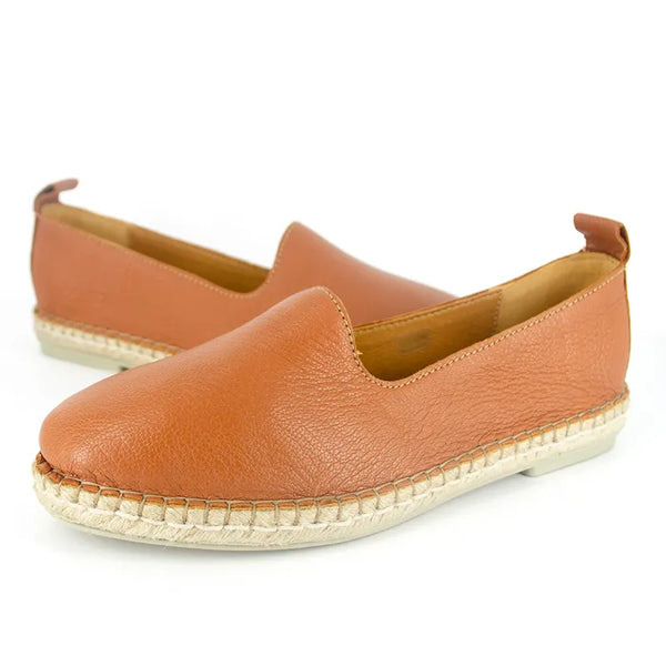 Pair of tan leather espadrilles on a white background
