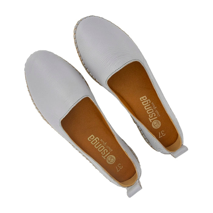 Light grey flat shoes with brown soles on a white background