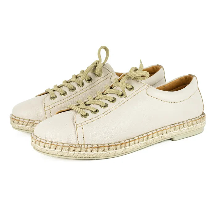 Pair of cream-coloured espadrille sneakers with beige laces on a white background