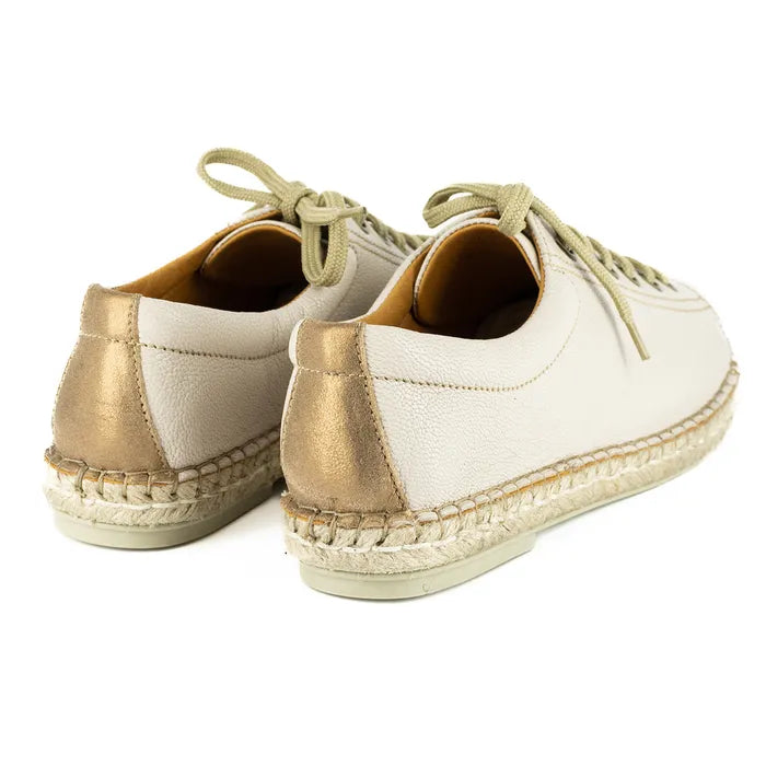 Pair of beige espadrille shoes with a gold accent on a white background
