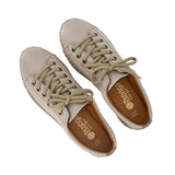Pair of beige sneakers with brown soles on a white background