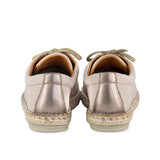 Pair of beige espadrille sneakers with a metallic detail on a white background