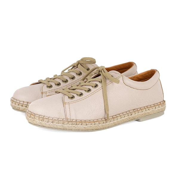 Pair of beige espadrille sneakers on a white background