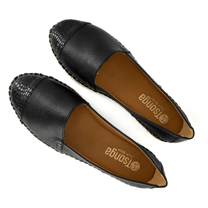 Black loafers with off white soles on a white background