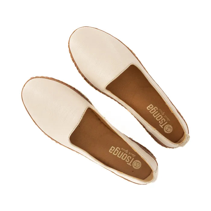 Pair of cream flat shoes with brown soles on a white background