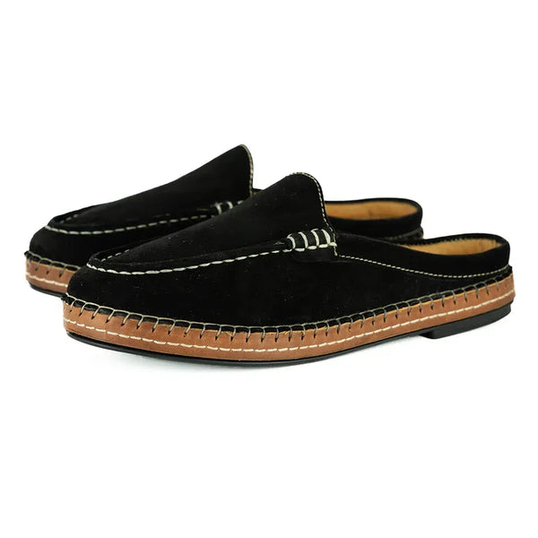 Pair of black mules with brown soles on a white background