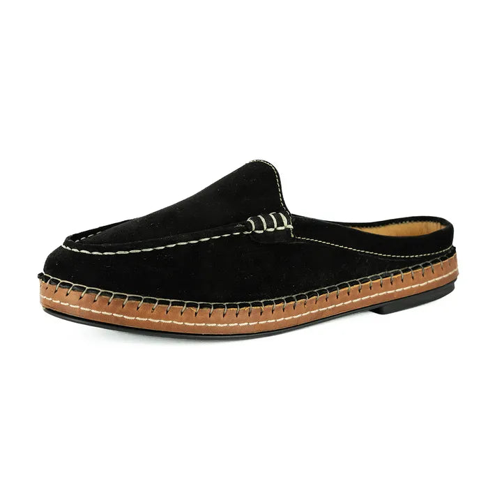 Black slip-on shoe with brown sole on a white background