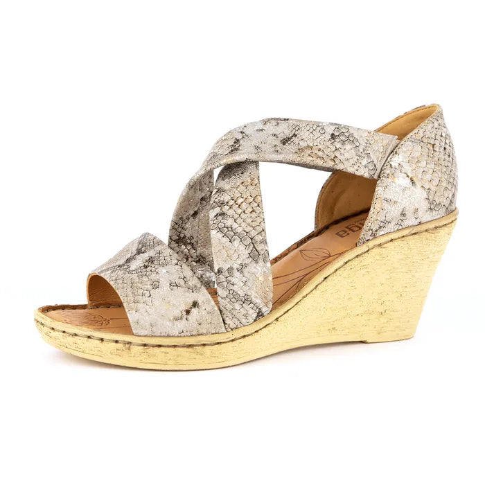 Wedge sandal with snake print straps on a white background