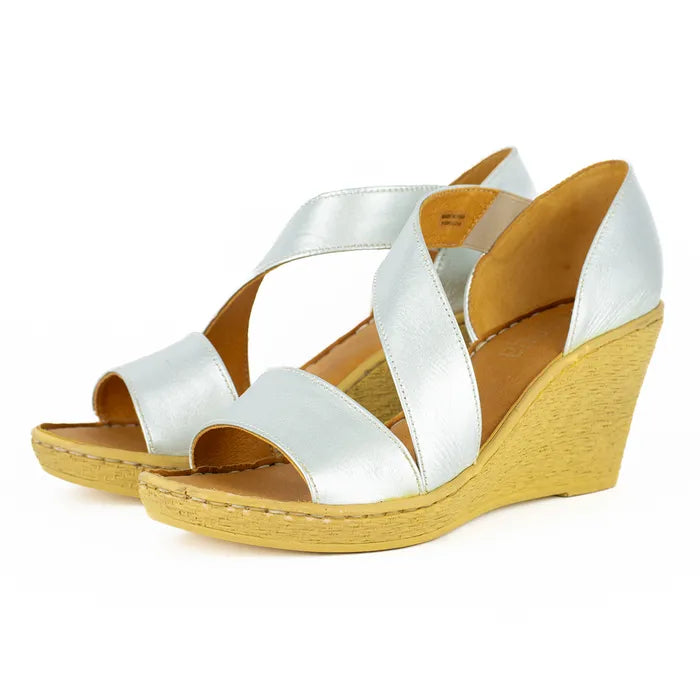 Silver wedge sandals with brown soles on a white background