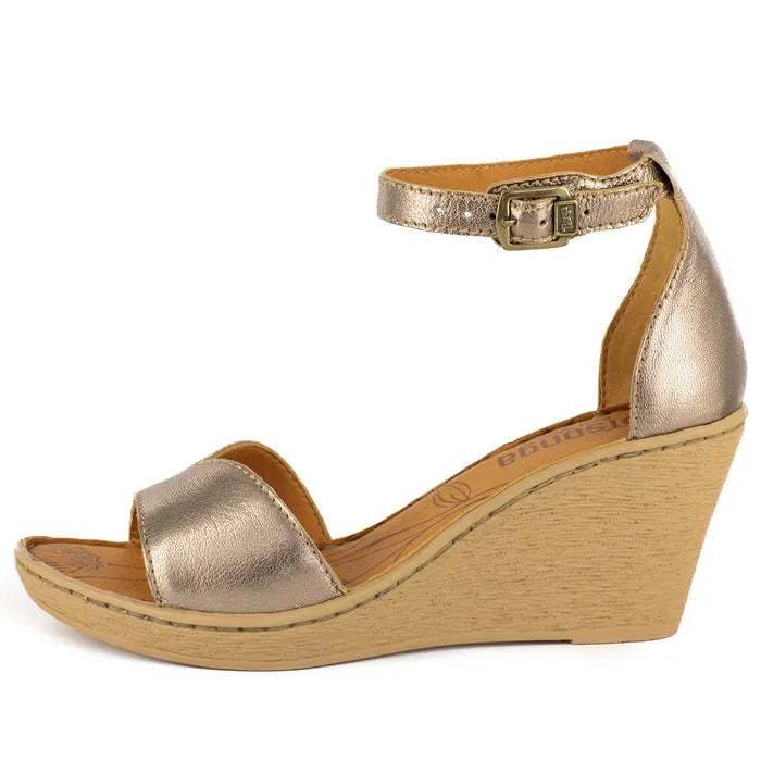 Gold wedge sandal on a wedge sole on a white background