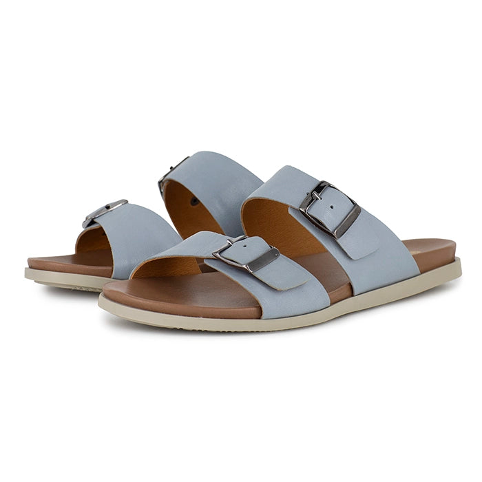 Pair of light blue sandals with tan soles on a white background